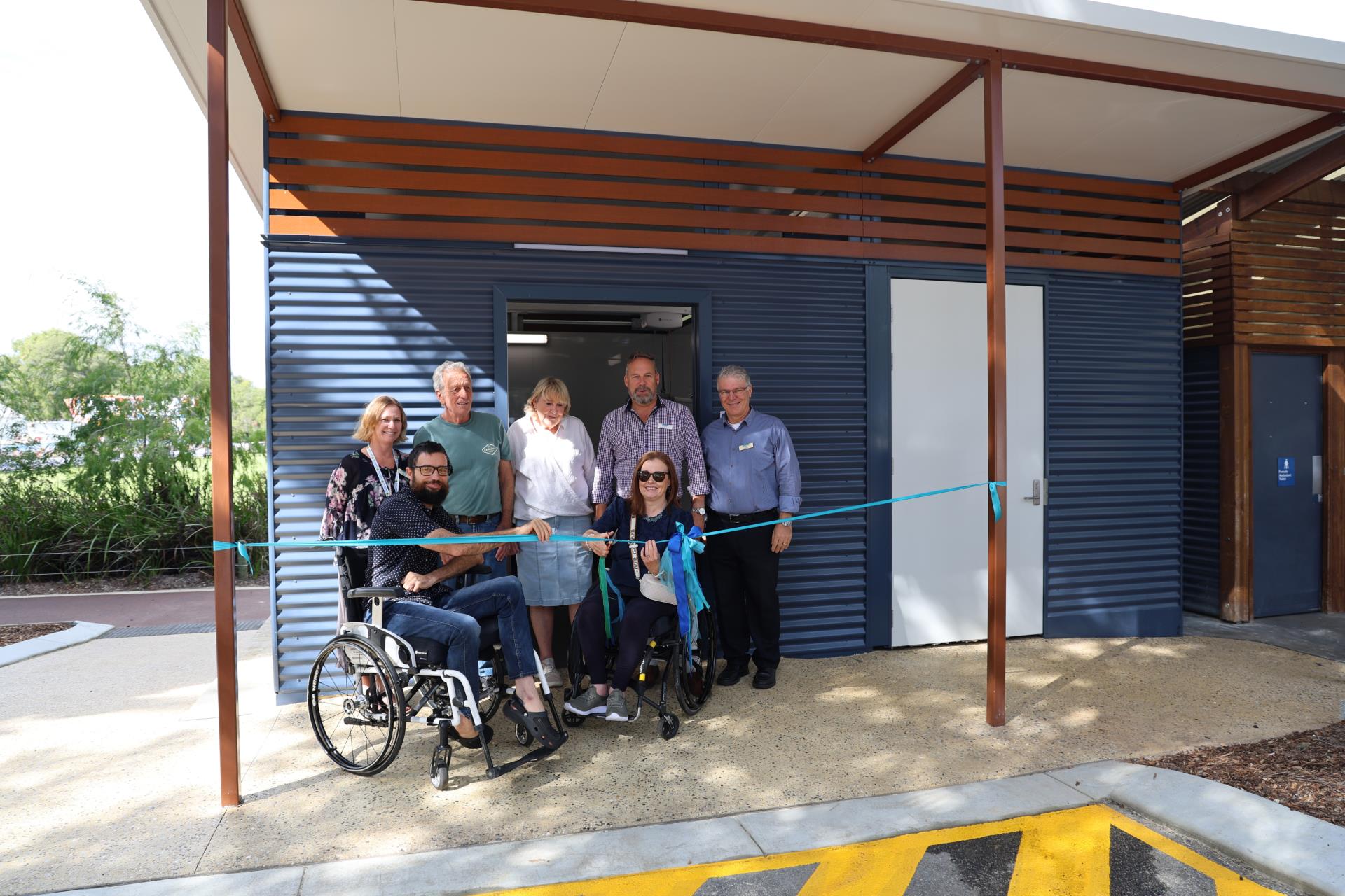 Ribbon cutting ceremony with Fraser and Anne-Marie cutting the ribbon outside new facility