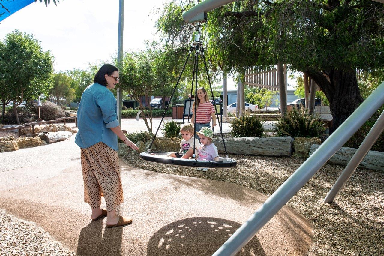 Children and Parents playing in a playground on a sunny day